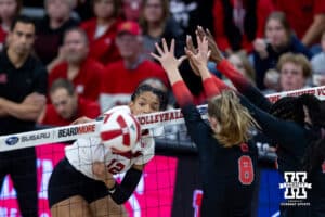 Nebraska Cornhusker outside hitter Taylor Landfair (12) spikes the ball past the Ohio State Buckeyes blockers during a volleyball match on Saturday, Nov. 29, 2025, in Lincoln, Nebraska. Photo by John S. Peterson.