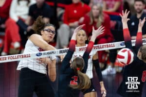 Nebraska Cornhusker middle blocker Rebekah Allick (5) spikes the ball between the Ohio State Buckeyes blockers during a volleyball match on Saturday, Nov. 29, 2025, in Lincoln, Nebraska. Photo by John S. Peterson.